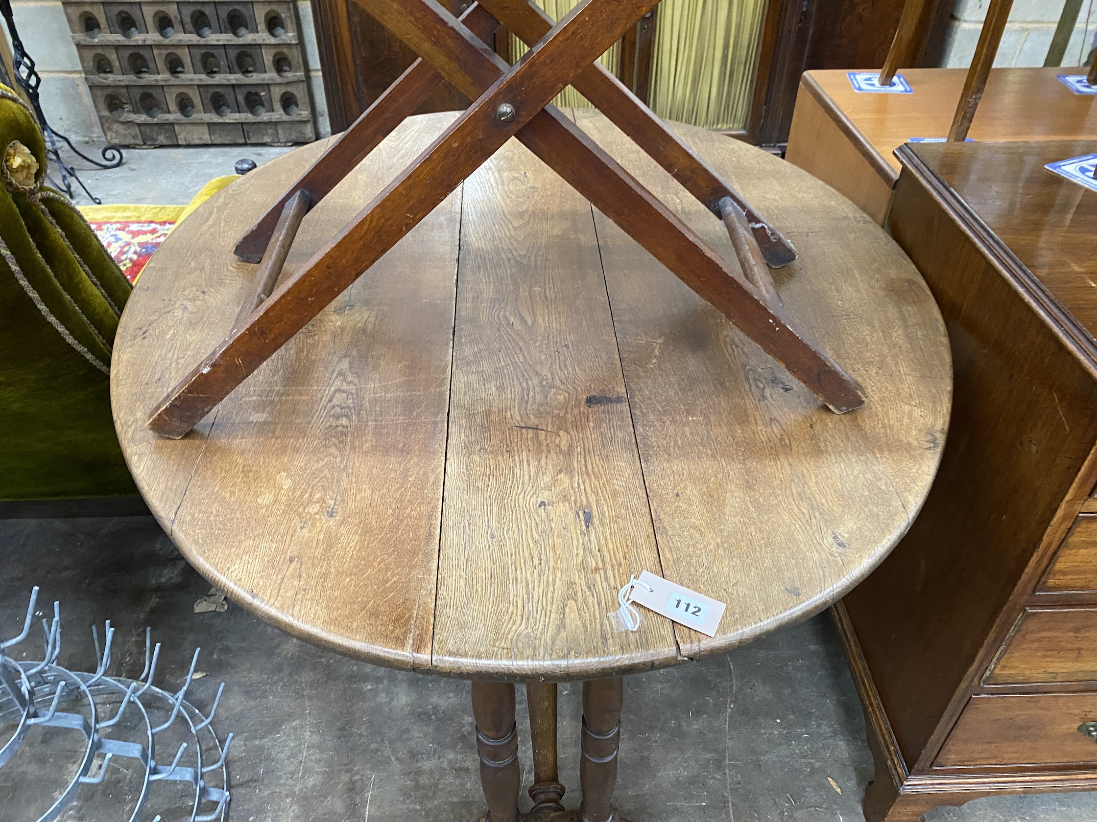 An early 20th century oak drop flap dining table, width 116cm, depth 98cm extended, height 70cm